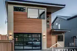 Modern two-story house with wood and beige exterior, large windows, and a glass-paneled garage door. The entryway is covered, and the house number 5618 is visible near the front door.
